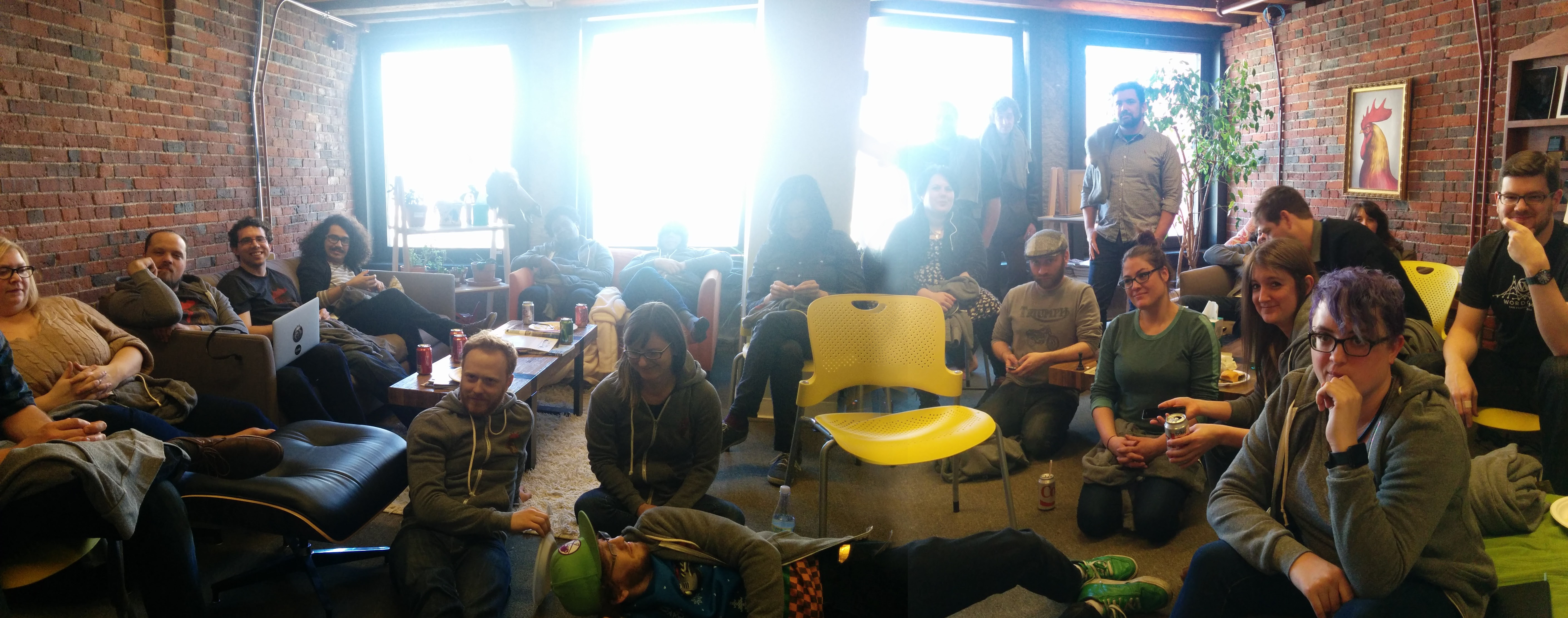 A group of about 25 people relaxing in a sunny lounge space